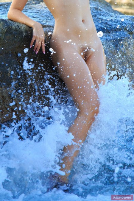 Девушка ню купается в море