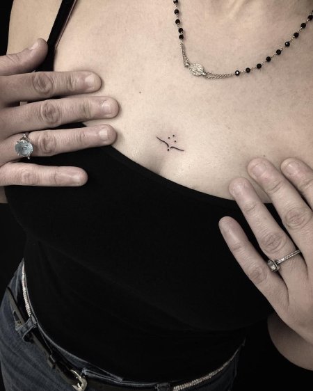 Тату между грудью маленькая