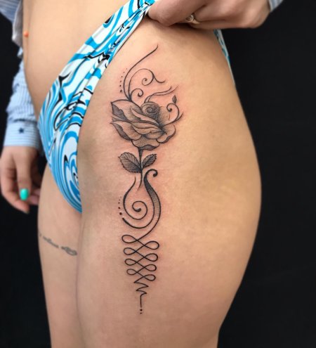 Женская татуировка на бедре