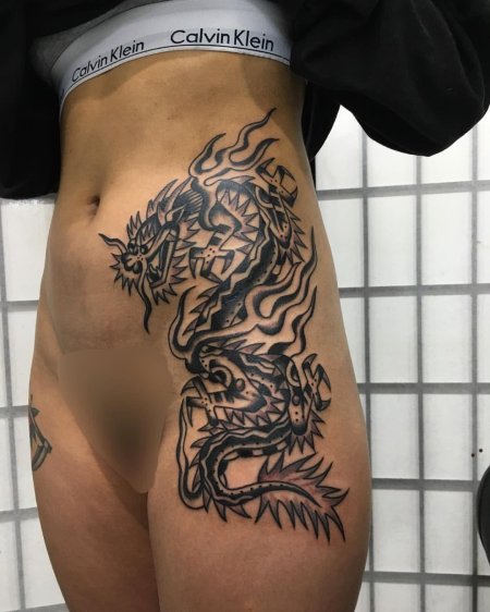 Тату дракона на бедре у девушки
