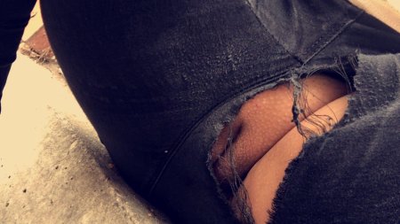 Девушка в порванных брюках