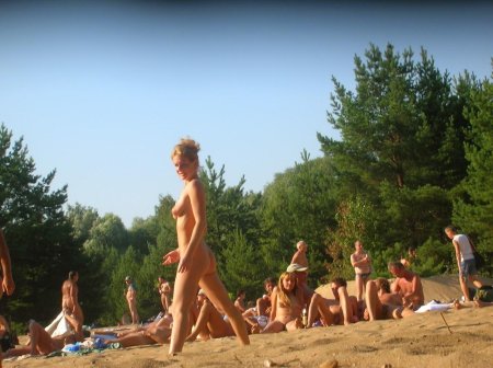 Загорает топлесс на общественном пляже